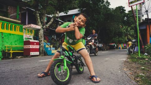 インドネシアの路上で自転車に乗って微笑む子供